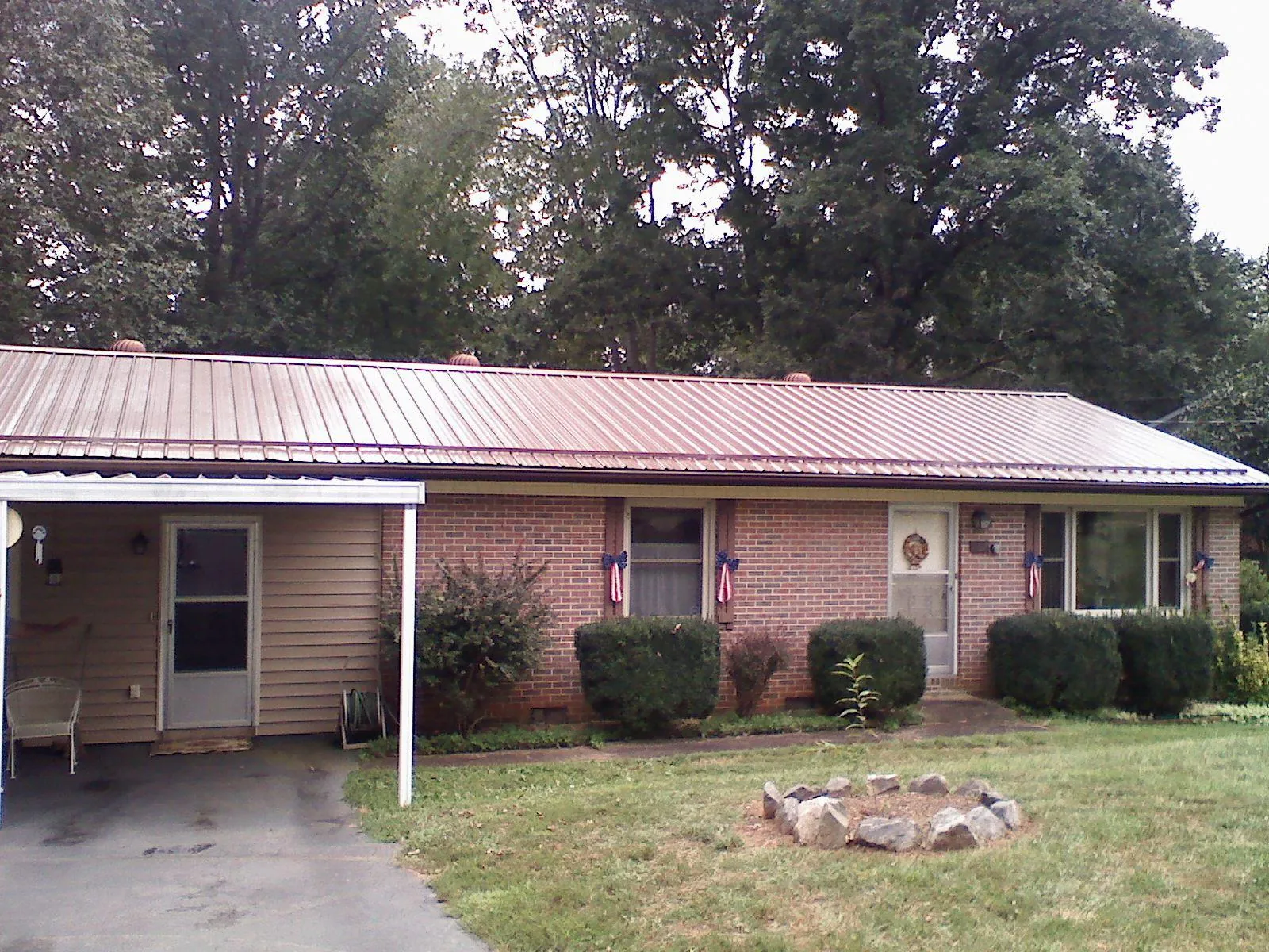 Bronze metal roof and carport on a brick ranch home — Roof Repair work by our crew in Warren